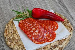 Chorizo on wooden board and wooden background photo