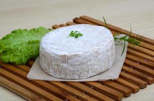 Camembert cheese on wooden board and wooden background photo