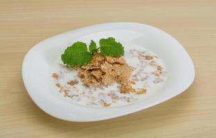 Cornflakes on the plate and wooden background photo