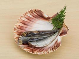 anchoa salada en un recipiente sobre fondo de madera foto