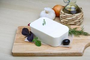 Feta cheese on wooden board and wooden background photo