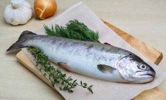 Raw trout on wooden board and wooden background photo