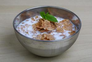 Cornflakes in a bowl on wooden background photo
