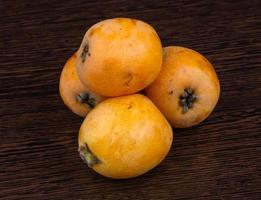 Medlar on wooden background photo