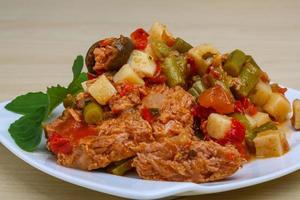 Nicoise salad on the plate and wooden background photo