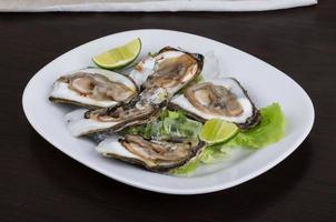 Fresh oyster on the plate and wooden background photo