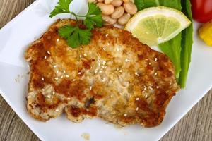 Pork schnitzel on the plate and wooden background photo