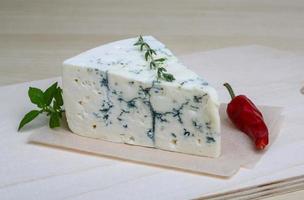 Blue cheese on wooden board and wooden background photo