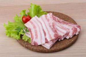 Sliced bacon on wood photo