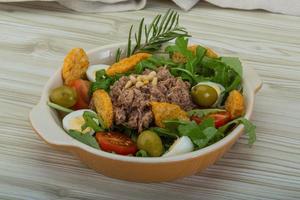 Tuna salad in a bowl on wooden background photo