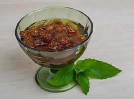 Mulberry jam in a bowl on wooden background photo