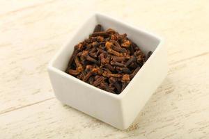 Clove in a bowl on wooden background photo