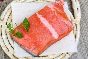 Salmon fillet on wooden board and wooden background photo