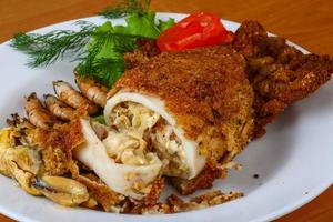 Stuffed squid on the plate and wooden background photo