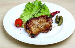 Roasted pork on the plate and wooden background photo