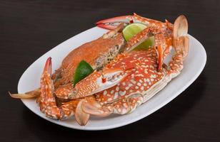 Boiled crabs on the plate and wooden background photo