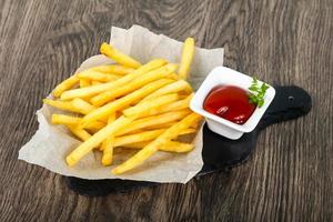 French fries on the plate and wooden background photo