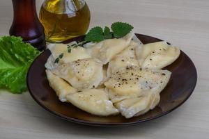 Vareniki on the plate and wooden background photo