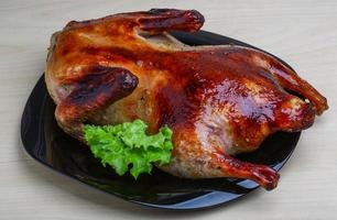 pato asado en el plato y fondo de madera foto