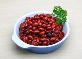 Canned beans in a bowl on wooden background photo