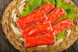 Crab sticks on wooden board and wooden background photo