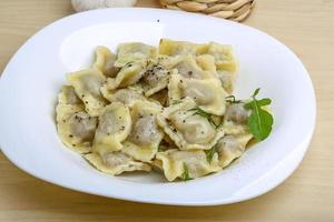 Ravioli on the plate and wooden background photo