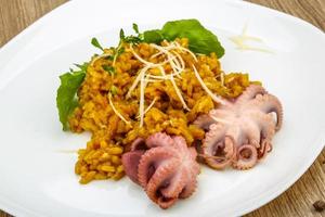 Seafood risotto on the plate and wooden background photo