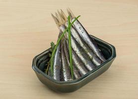 Salted anchovy in a bowl on wooden background photo