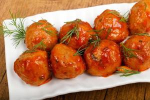 Meat balls on the plate and wooden background photo