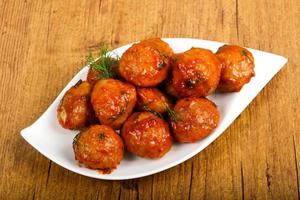 Meat balls on the plate and wooden background photo