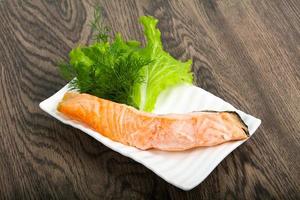 Steamed salmon on the plate and wooden background photo