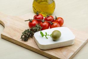 Feta cheese on wooden board and wooden background photo