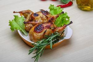 Roasted Quail in a bowl on wooden background photo