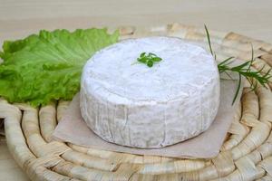 Brie cheese on wooden board and wooden background photo