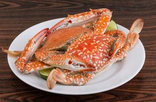 Boiled crabs on the plate and wooden background photo