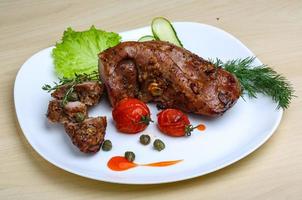 Pork tenderlion on the plate and wooden background photo