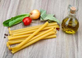 Bucatini pasta on wooden background photo