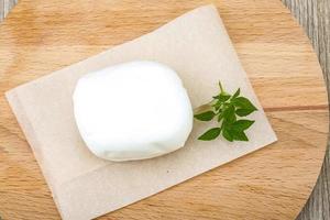 Mozzarella on wooden board and wooden background photo