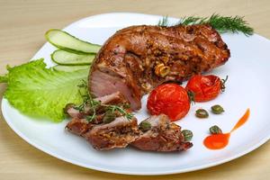 Pork tenderlion on the plate and wooden background photo