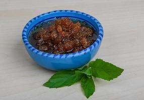 Mulberry jam in a bowl on wooden background photo