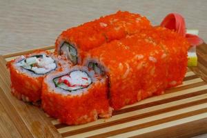 California roll on wooden board and wooden background photo