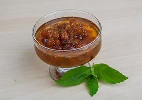 Mulberry jam in a bowl on wooden background photo