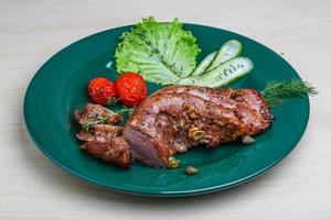 Pork tenderlion on the plate and wooden background photo