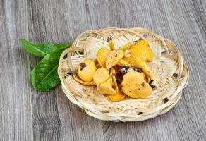 Chanterelle in a basket on wooden background photo