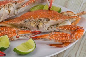 Boiled crabs on the plate and wooden background photo