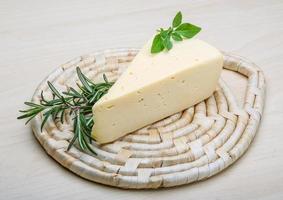 Yellow cheese on wooden board and wooden background photo