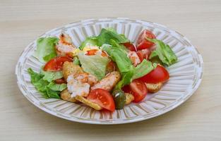 Caesar salad on the plate and wooden background photo