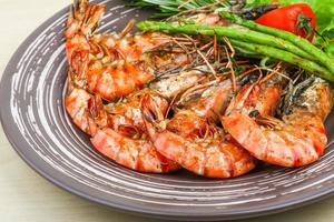 Grilled prawns on the plate and wooden background photo