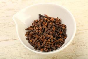 Clove in a bowl on wooden background photo