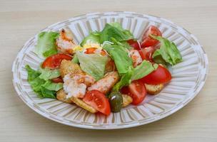 Caesar salad on the plate and wooden background photo